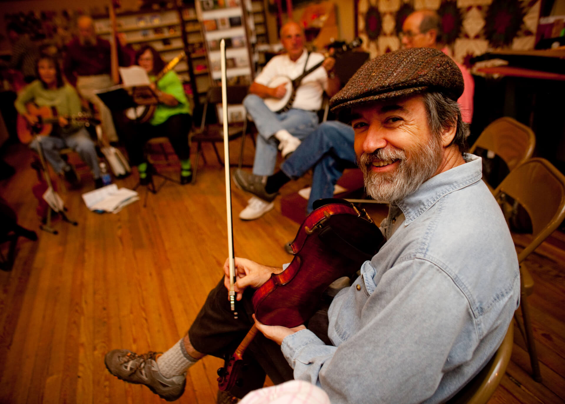 Musicians playing bluegrass instruments in circle during the holidays in Brevard