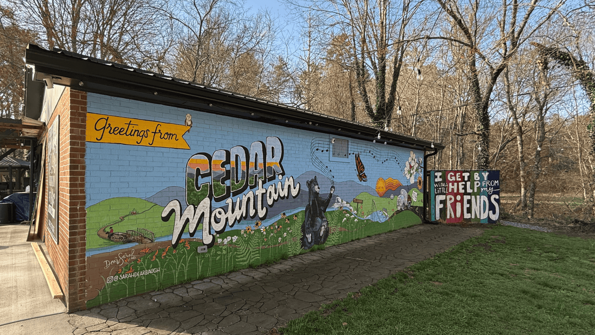 Postcard style mural on the side of Cedar Mountain Moonshine. 
