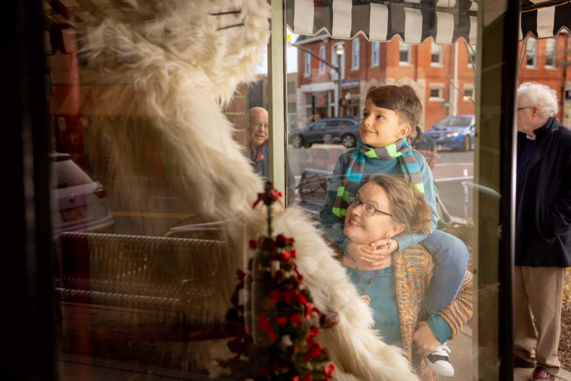 Mother and son looking into the window of a storefront at a white squirrel in Downtown Brevard