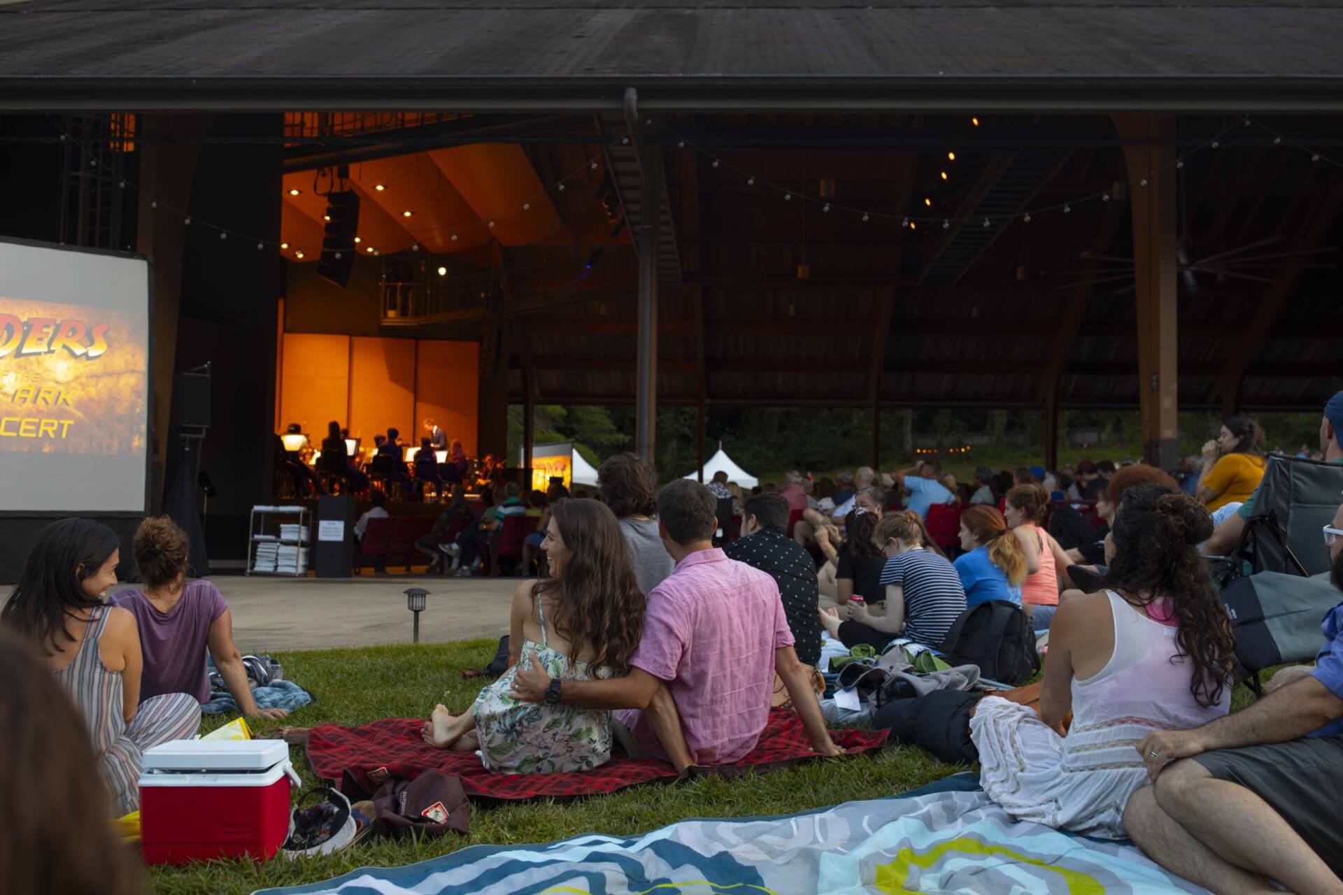 Couple sits on a blanket on the lawn at Brevard Music Center during the summer music series.