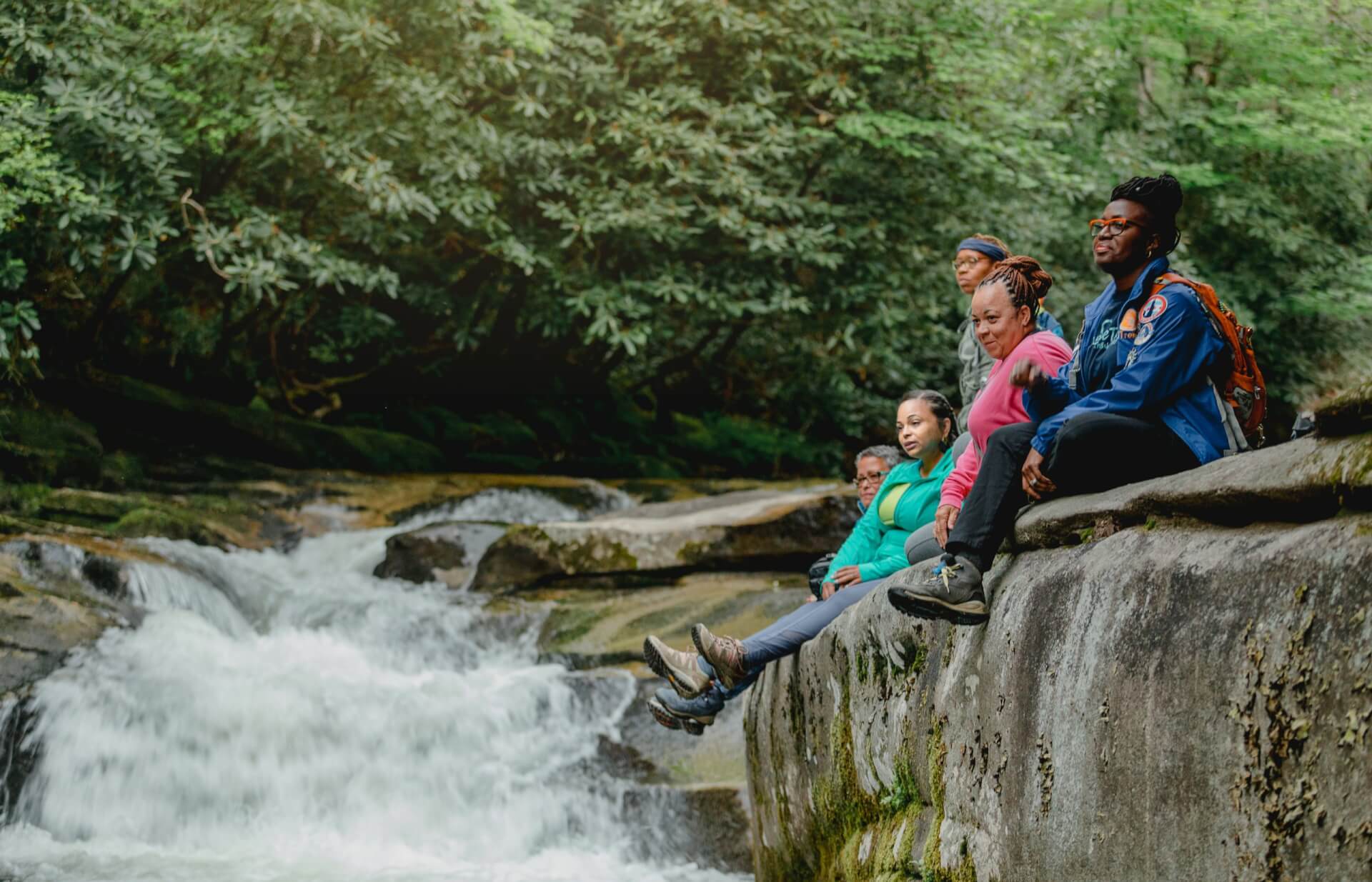 Women sitting on a rock while hiking in Pisgah National Forest