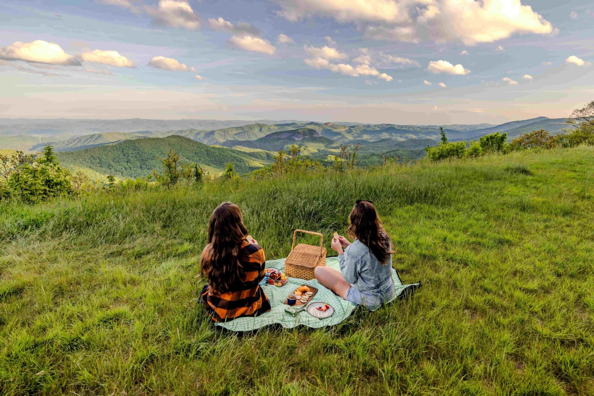 Two women enjoying a picnic on the Blue Ridge Parkway, overlooking Looking Glass Rock.