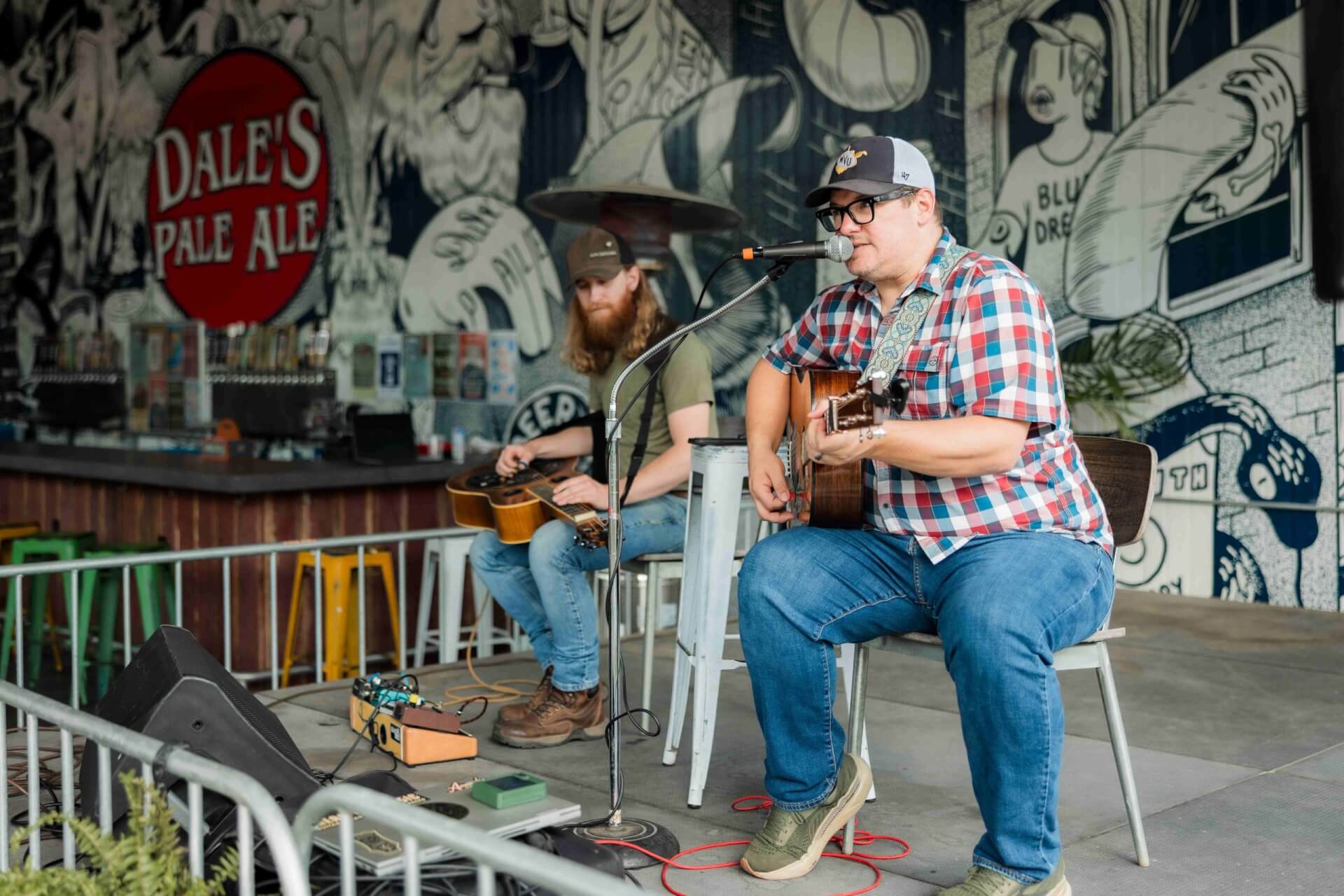 Cast Iron Bluegrass Duo playing instruments on the outdoor stage at Oskar Blues