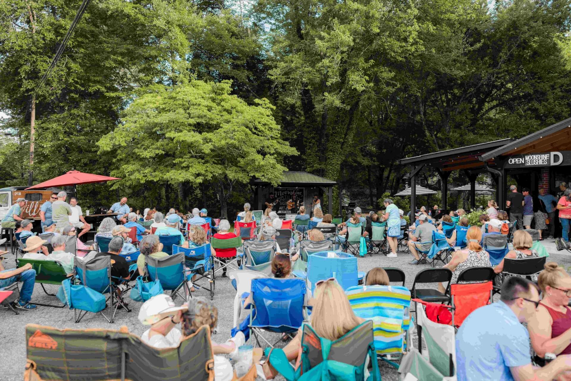 Large group gathered listening to music during Music + Moonshine at Cedar Mountain Moonshine